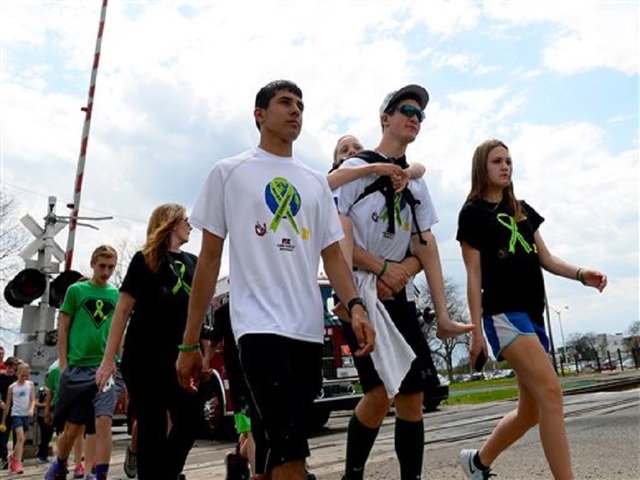 Teen carrying brother reaches Mich. Capitol